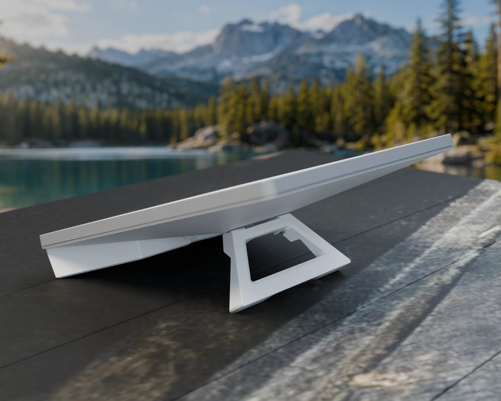Illustrative lakeside view of Mini and E100 Prime; the deployed stand and battery edge touch a weathered tabletop